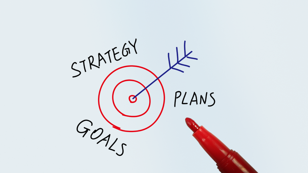 Red marker drawing a target with an arrow labeled strategy, goals, and plans